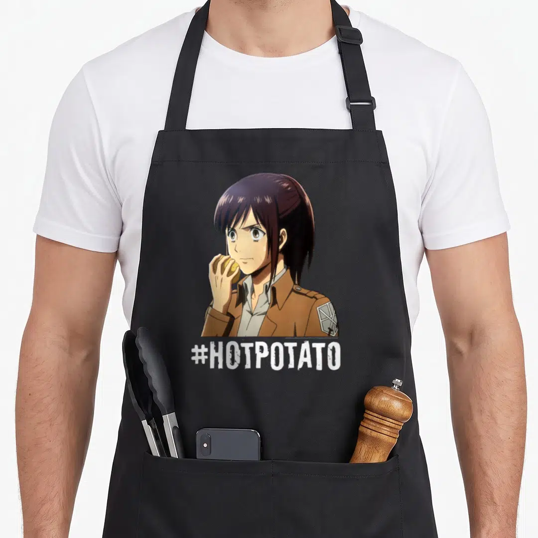 Hotpotato potato apron - Anime person in brown uniform eating yellow potato with white #HOTPOTATO text below — shown on a black cotton canvas apron against a white background