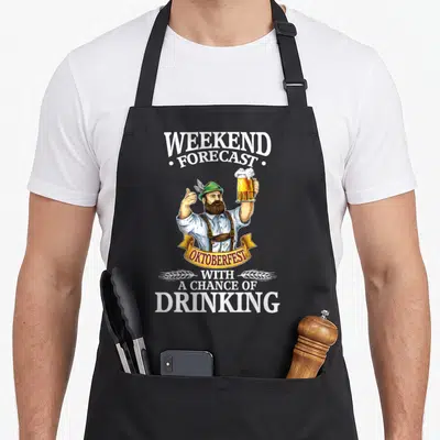 Beer oktoberfest apron - Cartoon man holding beer mug with text weekend forecast oktoberfest with a chance of drinking — shown on a black cotton canvas apron against a white background