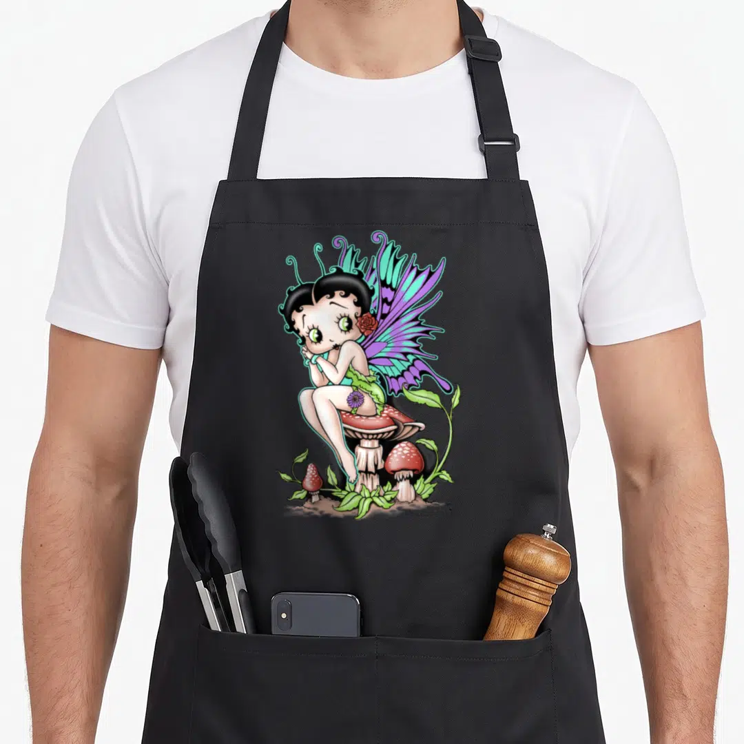 Funny fairy apron - Cartoon fairy with purple wings sitting on red mushroom with rose behind ear — shown on a black cotton canvas apron against a white background