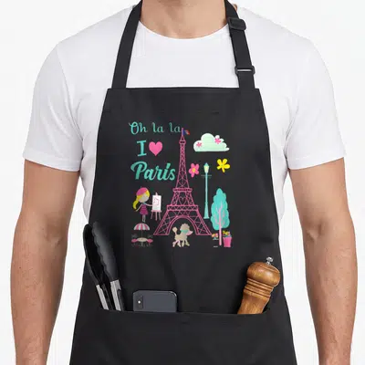 Tower french apron - Pink Eiffel Tower with Oh la la I love Paris text, girl painter, poodle, lamp post, and cloud — shown on a black cotton canvas apron against a white background
