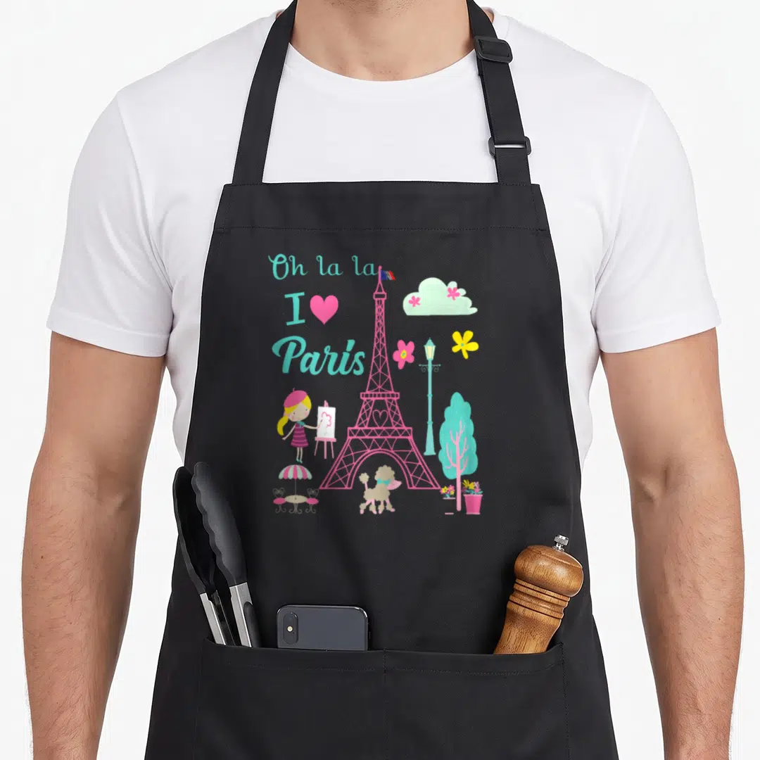 Tower french apron - Pink Eiffel Tower with Oh la la I love Paris text, girl painter, poodle, lamp post, and cloud — shown on a black cotton canvas apron against a white background