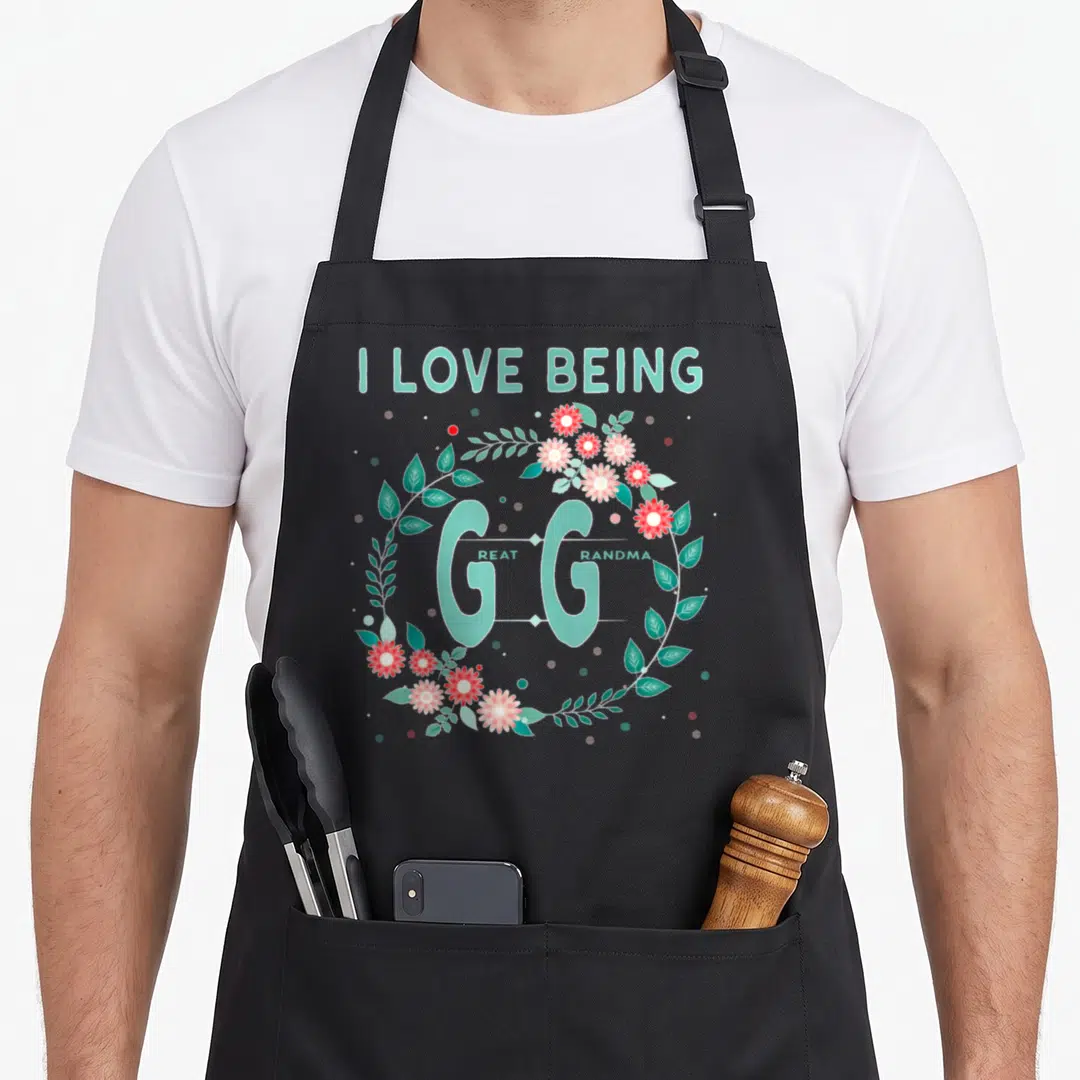 Gigi grandmother apron - Mint green I Love Being Great Grandma text inside a red and pink flower wreath — shown on a black cotton canvas apron against a white background