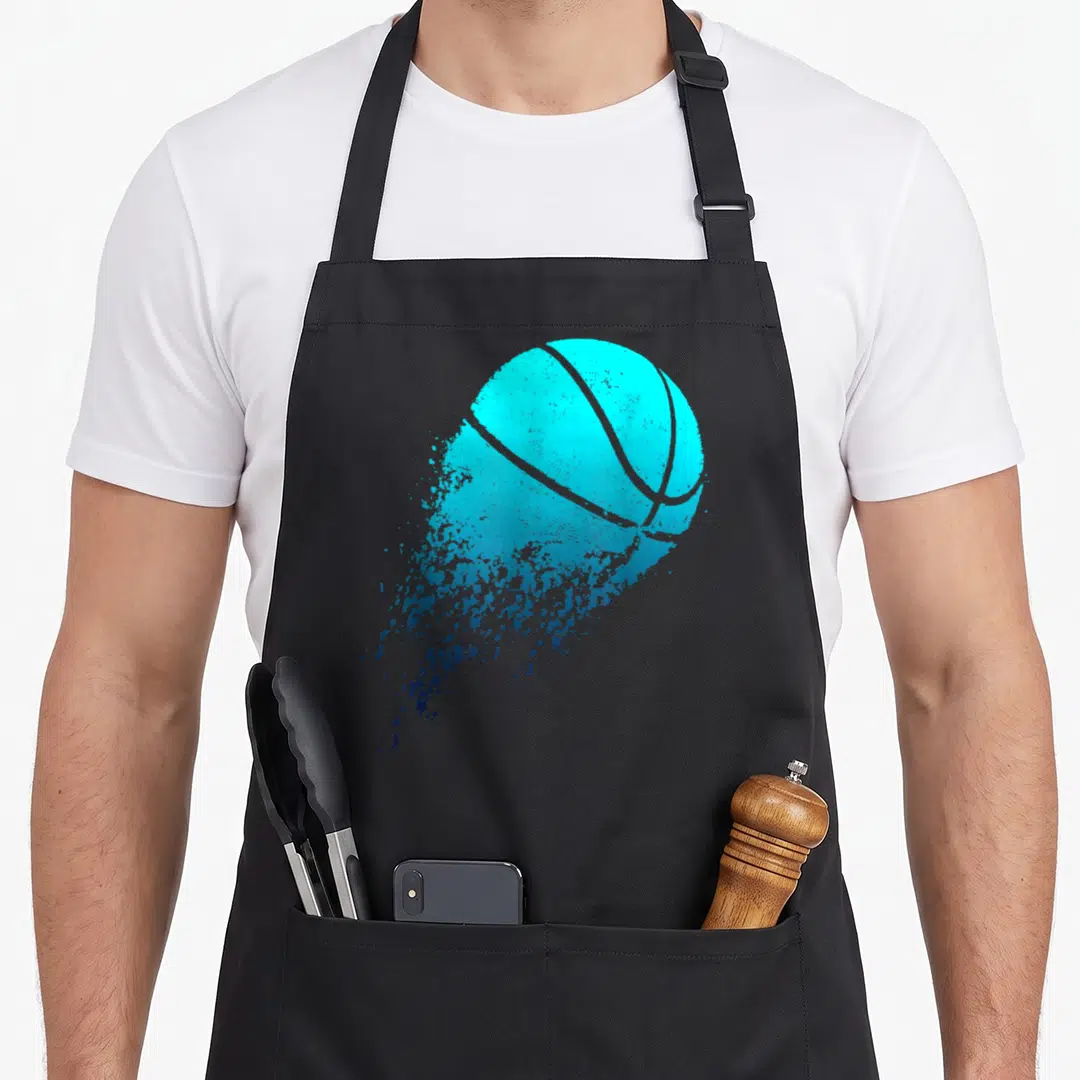 Coach basketball apron - Cyan basketball dissolving into blue paint splatter with two front pockets — shown on a black cotton canvas apron against a white background
