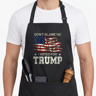 Blame distressed apron - Portrait of Donald Trump over distressed flag with text DON'T BLAME ME I VOTED FOR TRUMP — shown on a black cotton canvas apron against a white background