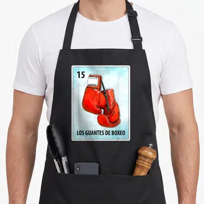Los mexican apron - Red boxing gloves on light blue card with number 15 and Spanish text LOS GUANTES DE BOXEO — shown on a black cotton canvas apron against a white background
