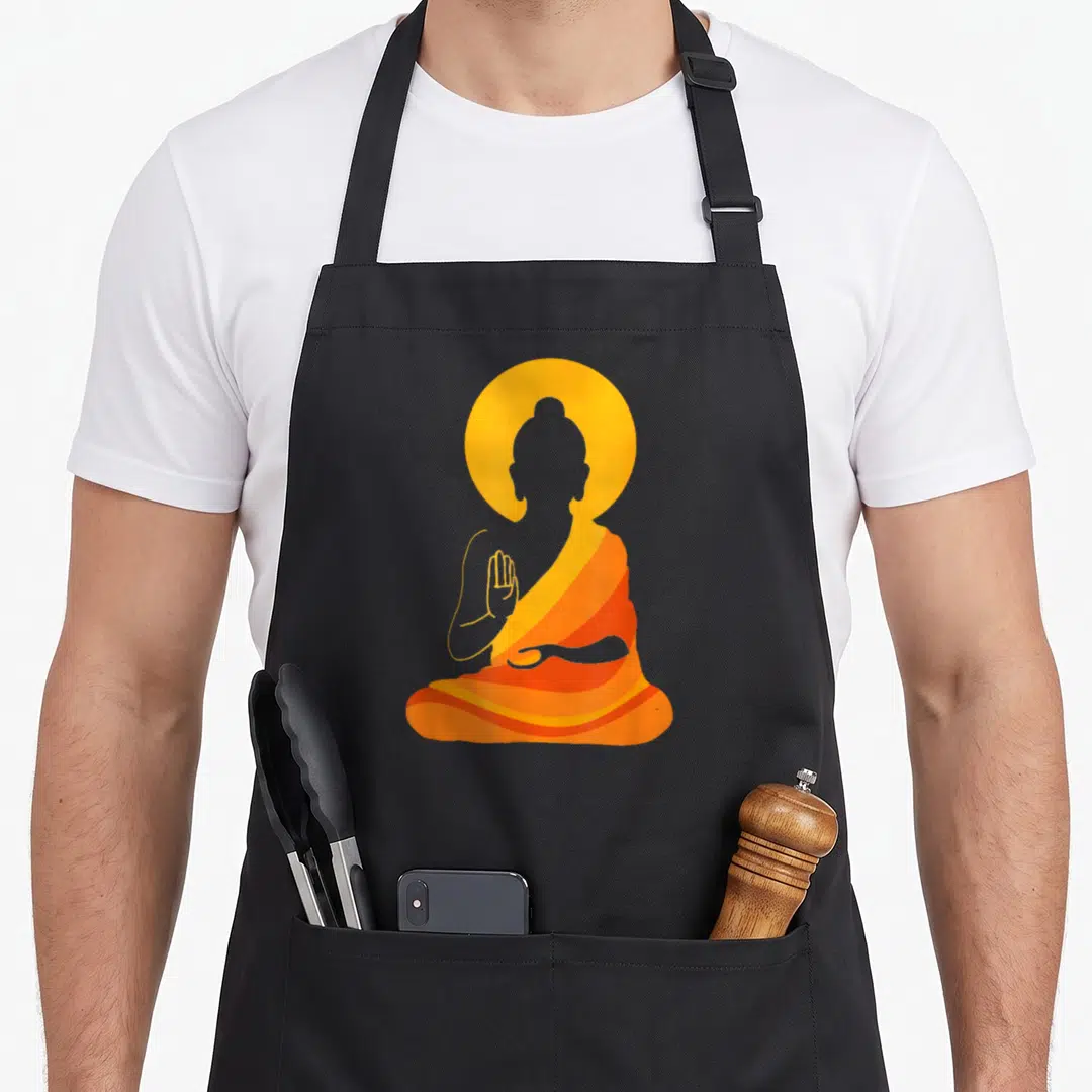 Buddha yin yoga apron - Minimalist Buddha silhouette in orange and yellow robes with circular halo behind head — shown on a black cotton canvas apron against a white background