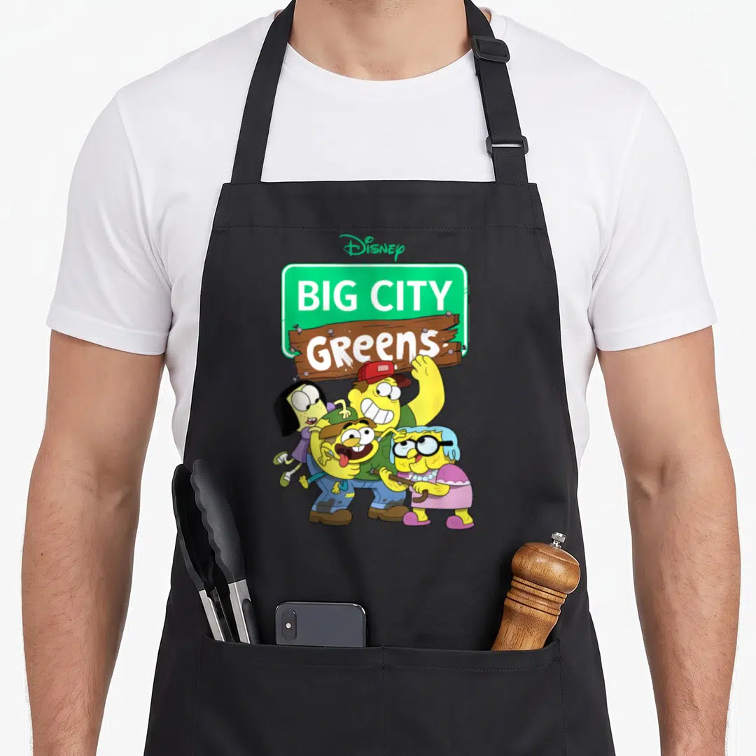 Channel novelty apron - Big City Greens sign with three yellow cartoon characters and Disney logo — shown on a black cotton canvas apron against a white background