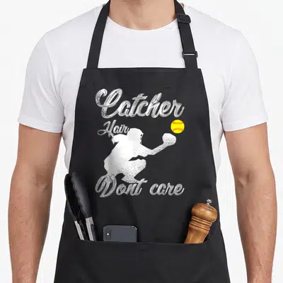 Player softball apron - Distressed catcher silhouette reaching for yellow ball with text Catcher Hair Dont care — shown on a black cotton canvas apron against a white background
