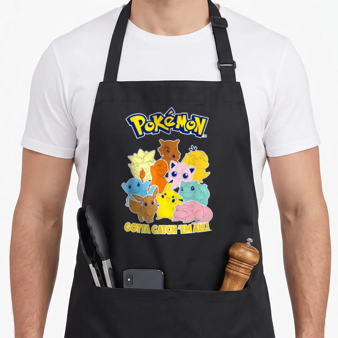 Pok mon novelty apron - Pokemon logo, colorful creature cluster, gotta catch em all slogan — shown on a black cotton canvas apron against a white background