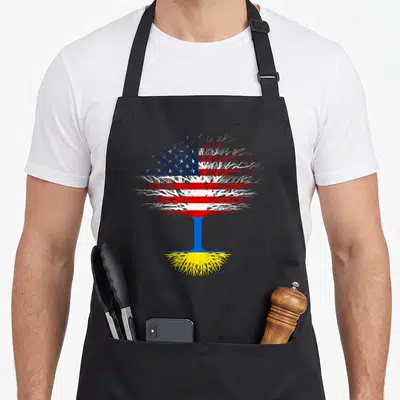 Ukraine tree apron - Stylized tree with US flag canopy, blue trunk, and yellow roots on black background — shown on a black cotton canvas apron against a white background