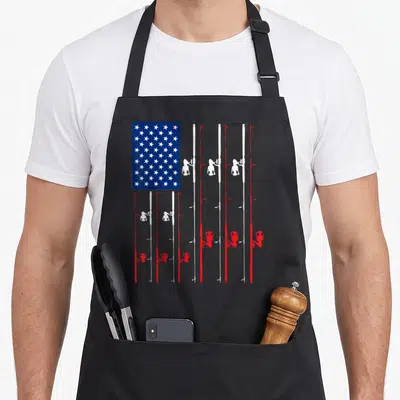 Rod fishing aprons - USA flag design with red white blue fishing rods and reels forming stripes — shown on a black cotton canvas apron against a white background