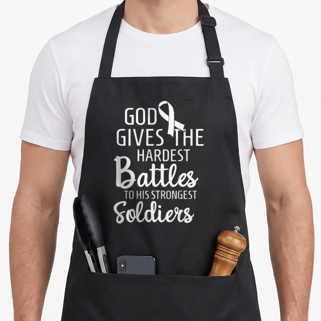 Motivational ribbon apron - White awareness ribbon beside stacked text reading God Gives The Hardest Battles — shown on a black cotton canvas apron against a white background