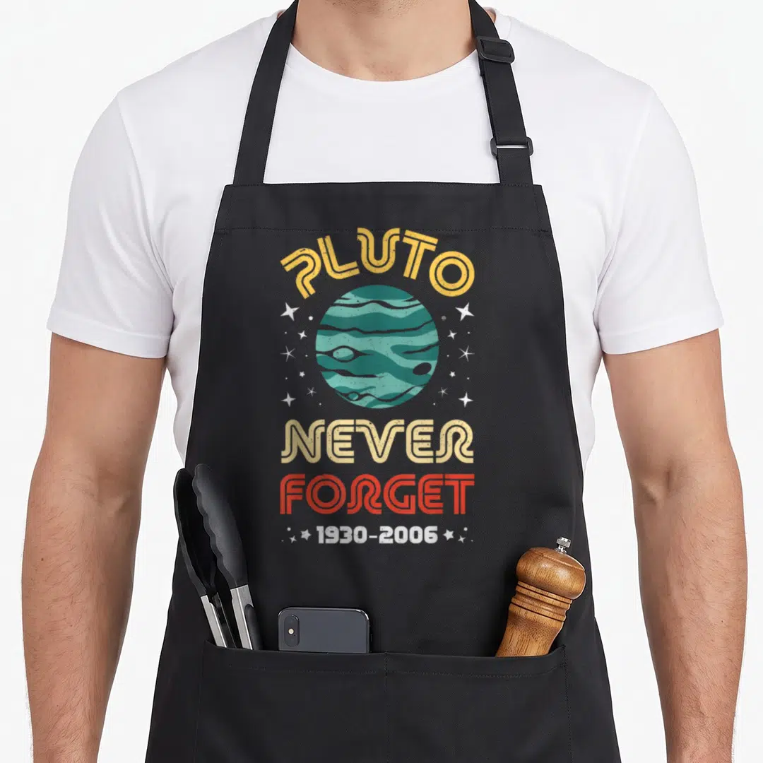 Forget pluto science apron - Retro teal planet with arched PLUTO text and stacked NEVER FORGET 1930-2006 dates — shown on a black cotton canvas apron against a white background
