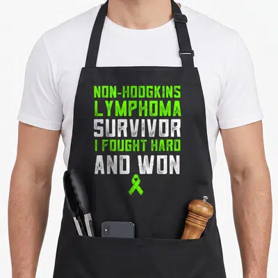 Non lime apron - Non-Hodgkins Lymphoma Survivor text and lime green ribbon on black bib — shown on a black cotton canvas apron against a white background