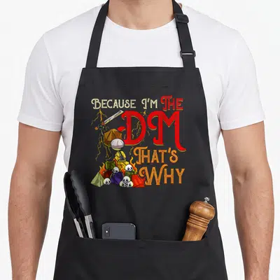 Cool novelty apron for the grill master - d20 character holding sword on dice pile with DM text — shown on a black cotton canvas apron against a white background