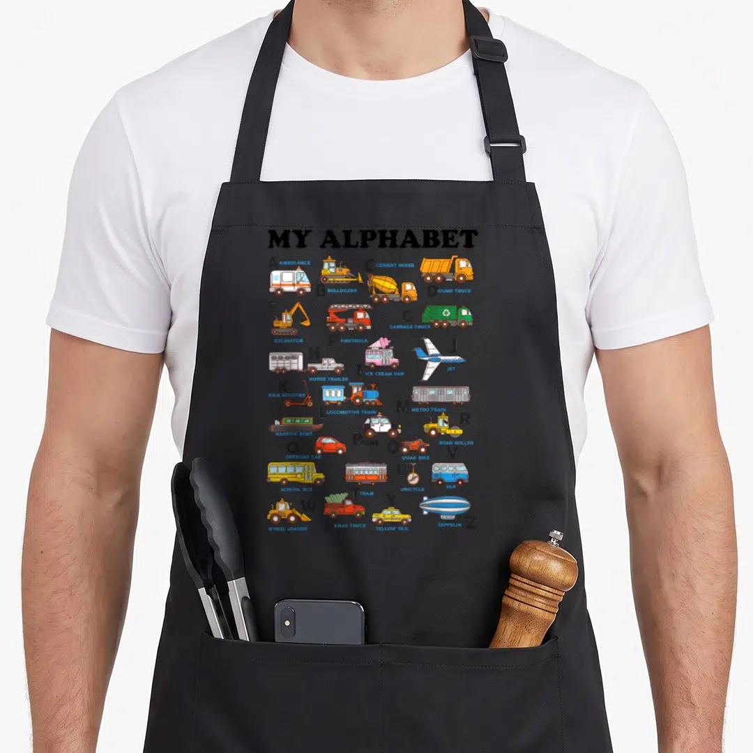 Abc vehicle apron - Cartoon vehicles A to Z including ambulance, bulldozer, and zeppelin under MY ALPHABET title — shown on a black cotton canvas apron against a white background