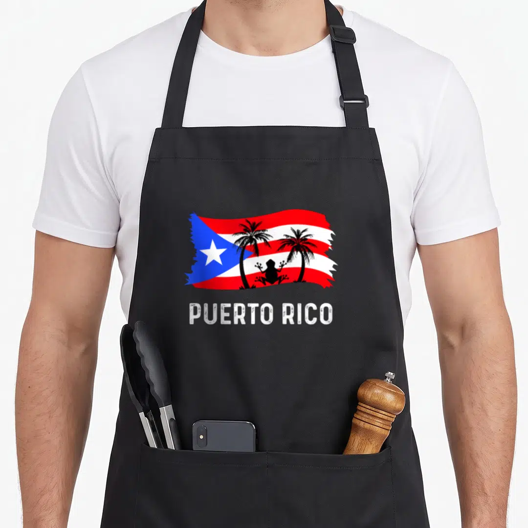 Rico frog aprons - Waving Puerto Rico flag with two black palm trees, frog silhouette, and distressed PUERTO RICO text — shown on a black cotton canvas apron against a white background