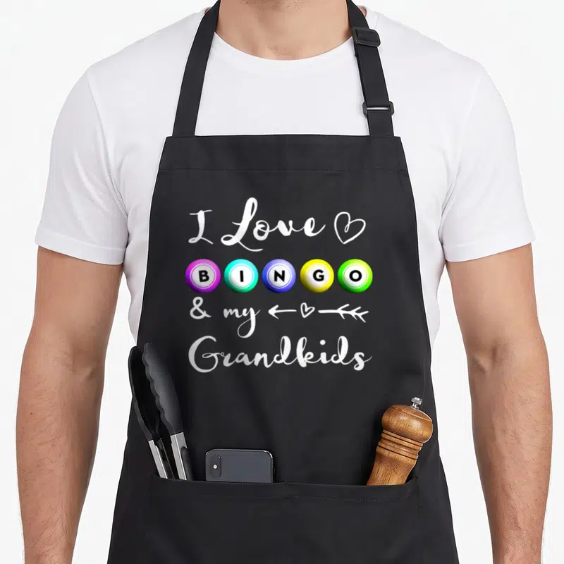 Bingo nana aprons - I Love BINGO & my Grandkids text with purple blue yellow green balls and white script — shown on a black cotton canvas apron against a white background