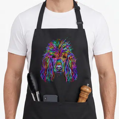 Poodle splash aprons - Multicolored cartoon poodle head in splash art style on black background — shown on a black cotton canvas apron against a white background