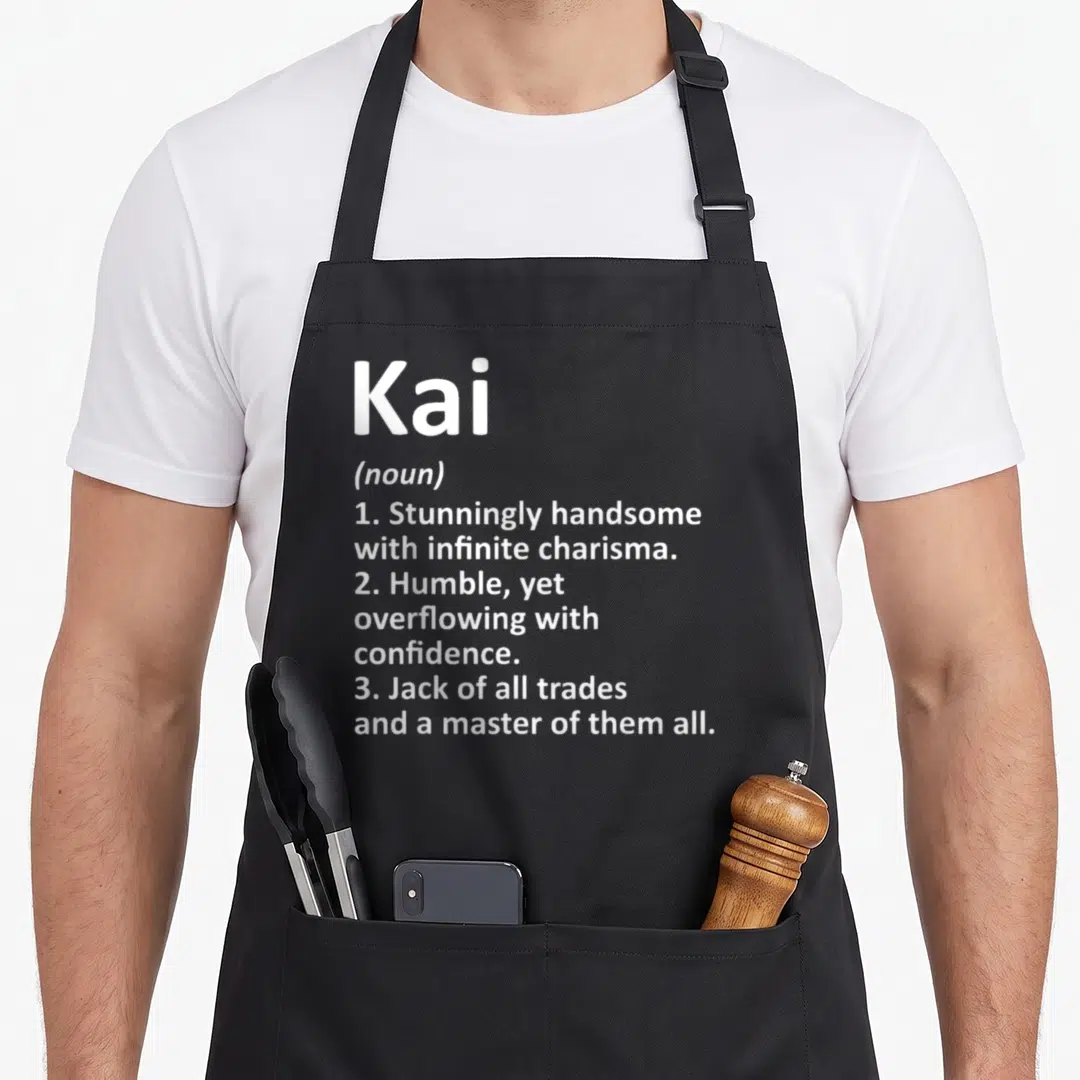 Kai father day aprons - White text defining Kai as handsome, humble, and a master of all trades on a grey background — shown on a black cotton canvas apron against a white background