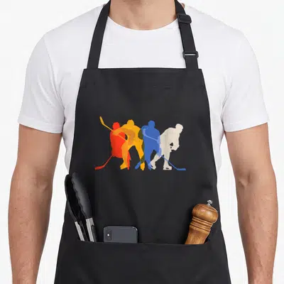 Ice hockey player apron - Four overlapping hockey player silhouettes in red, orange, blue, and white minimalist graphic — shown on a black cotton canvas apron against a white background