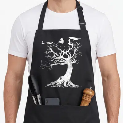 Tree goth gothic apron - White distressed leafless tree with five birds printed on dark fabric — shown on a black cotton canvas apron against a white background