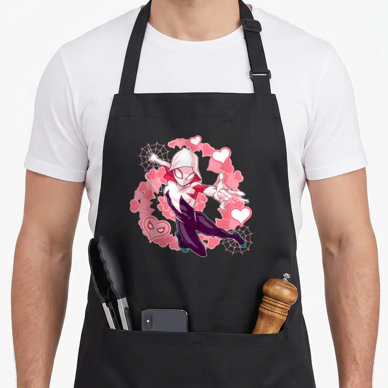 Spider animal apron - Hooded superhero with pink hearts and two spider webs in cartoon style — shown on a black cotton canvas apron against a white background