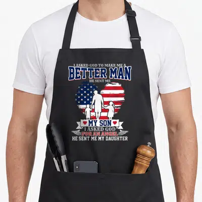 Better mom daughter apron - Patriotic heart with family silhouettes and text about God sending a son and daughter — shown on a black cotton canvas apron against a white background