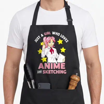 Sketching hobby anime apron - Anime girl with pink hair holding pencil and sketchpad surrounded by yellow stars — shown on a black cotton canvas apron against a white background