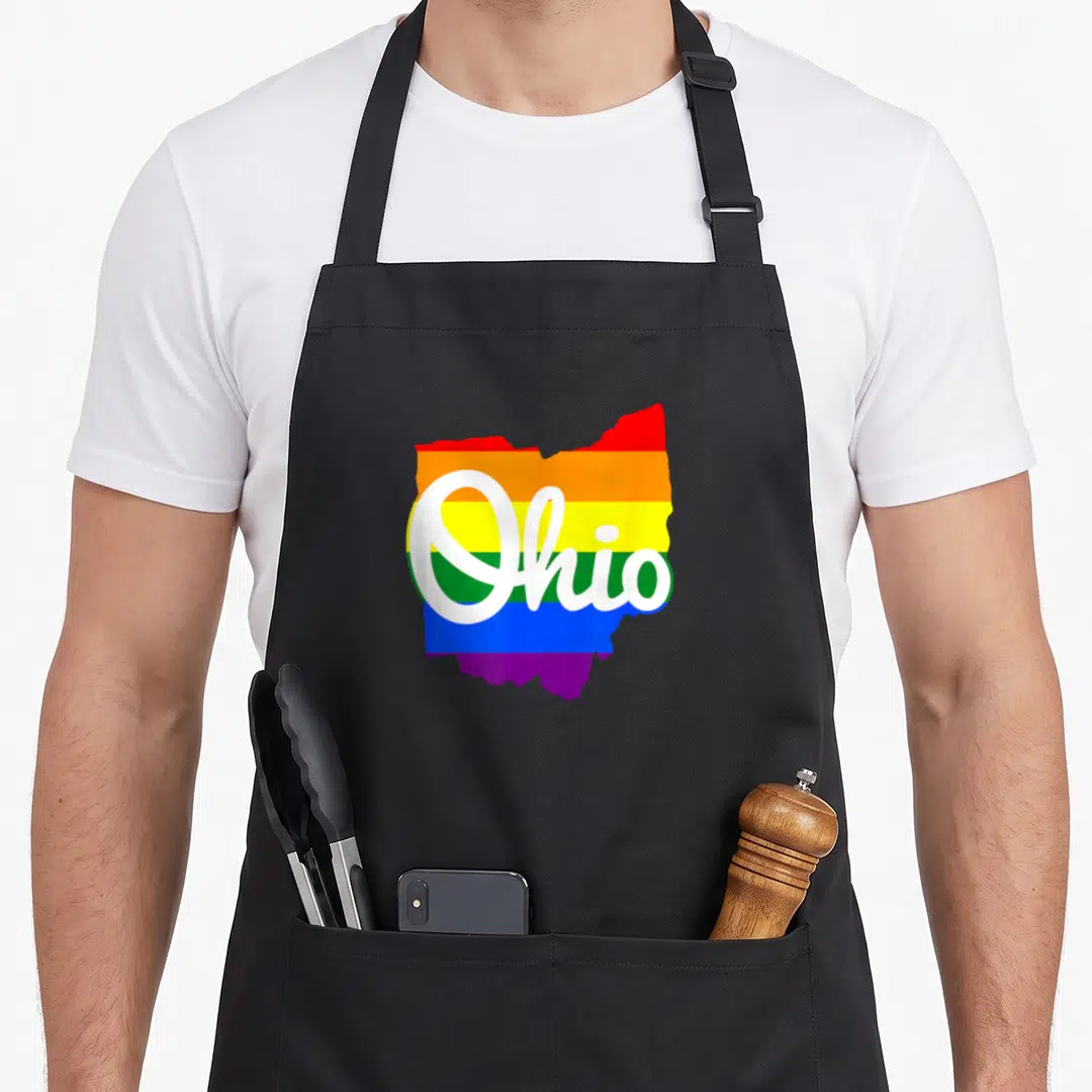 Ohio script pride apron - Rainbow striped Ohio state map with white script lettering — shown on a black cotton canvas apron against a white background