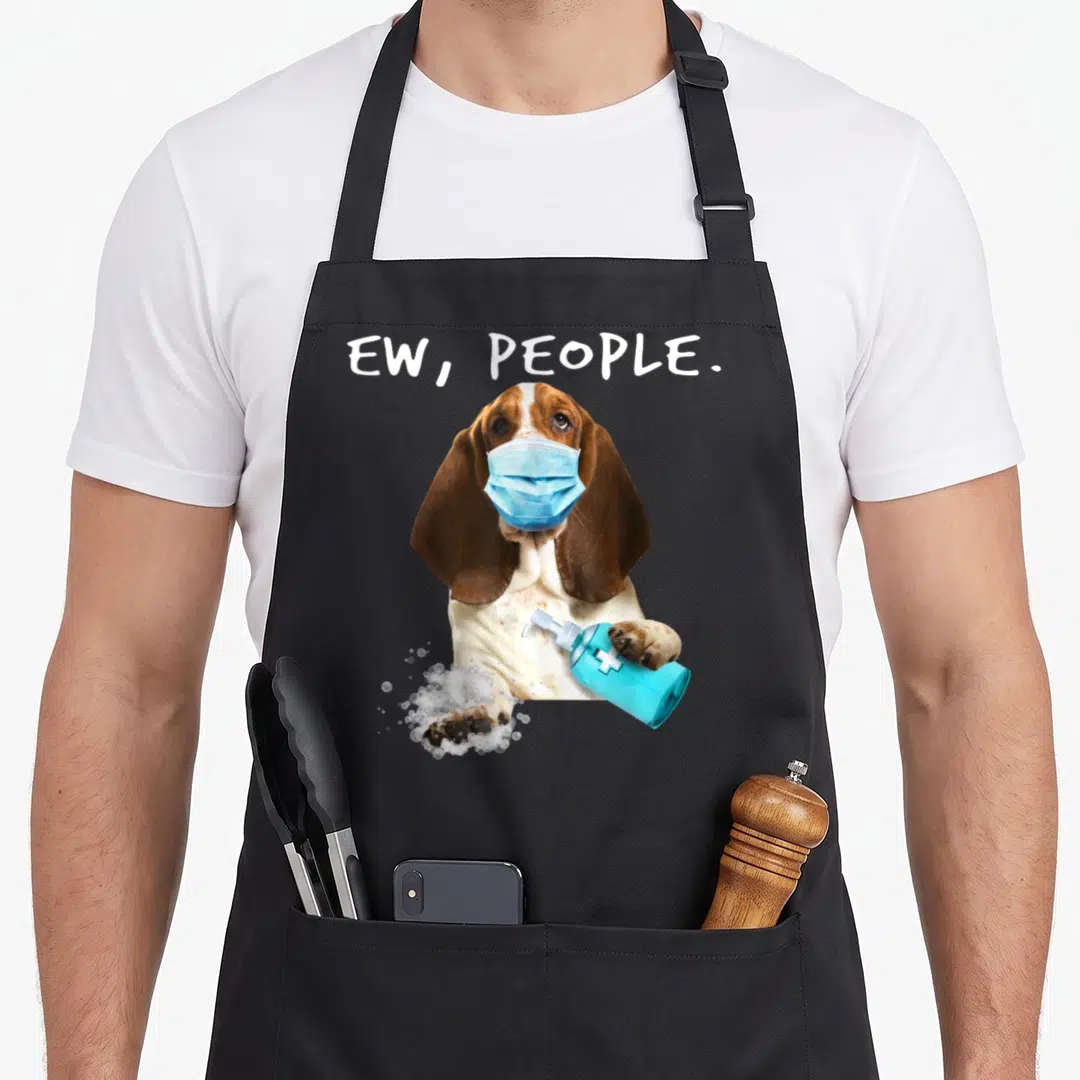 Basset face apron - Basset hound in blue mask holding sanitizer bottle with bubbles and text — shown on a black cotton canvas apron against a white background
