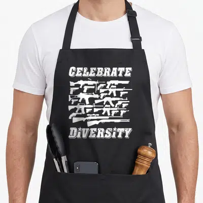 Diversity 2nd apron - White guns arranged between CELEBRATE and DIVERSITY text in distressed style — shown on a black cotton canvas apron against a white background