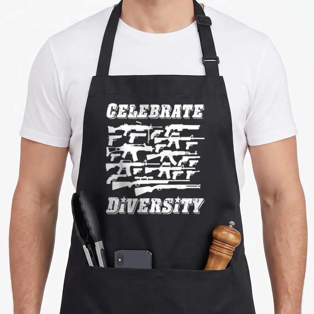 Diversity 2nd apron - White guns arranged between CELEBRATE and DIVERSITY text in distressed style — shown on a black cotton canvas apron against a white background