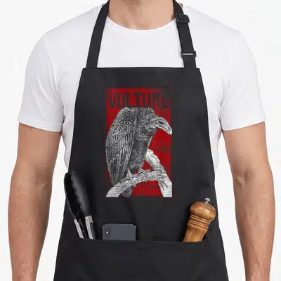 Africa bird apron - VULTURE text above perched white bird on distressed red background — shown on a black cotton canvas apron against a white background
