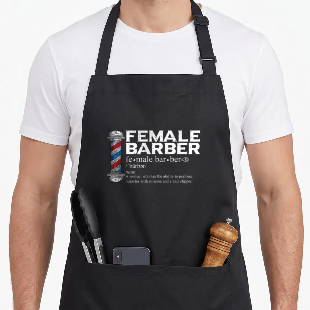 Barber hairdresser hairstylist apron - Distressed FEMALE BARBER dictionary text next to red white and blue barber pole — shown on a black cotton canvas apron against a white background