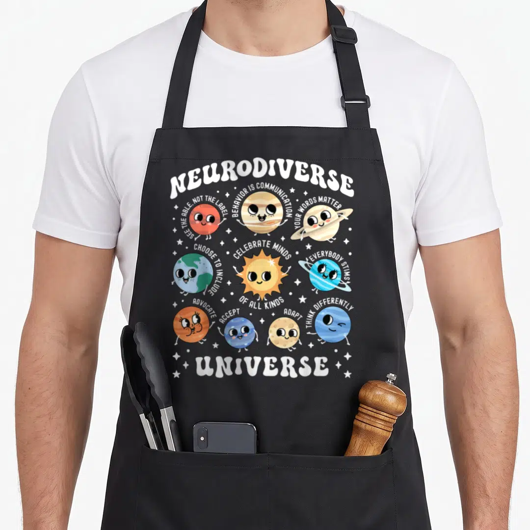 Neurodiverse special aprons - Cartoon planets with arched text Neurodiverse Universe and supportive messages — shown on a black cotton canvas apron against a white background
