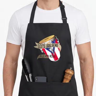 Rico salsa apron - Conga drum wrapped in Puerto Rican flag with beige ribbons reading 100% Salsero Puerto Rico — shown on a black cotton canvas apron against a white background