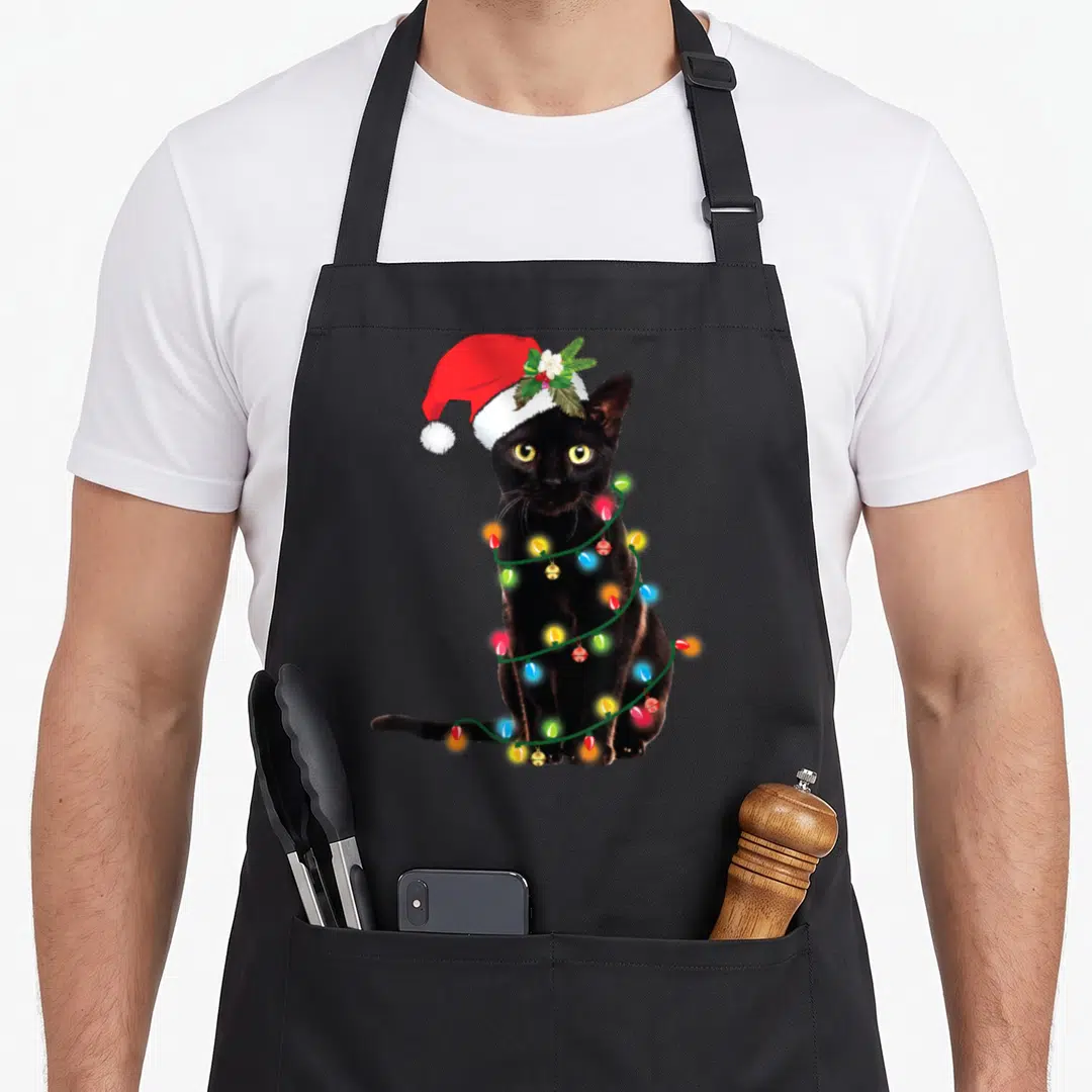 Santa light up christmas tree apron - Realistic black cat wearing Santa hat wrapped in red green yellow and blue — shown on a black cotton canvas apron against a white background