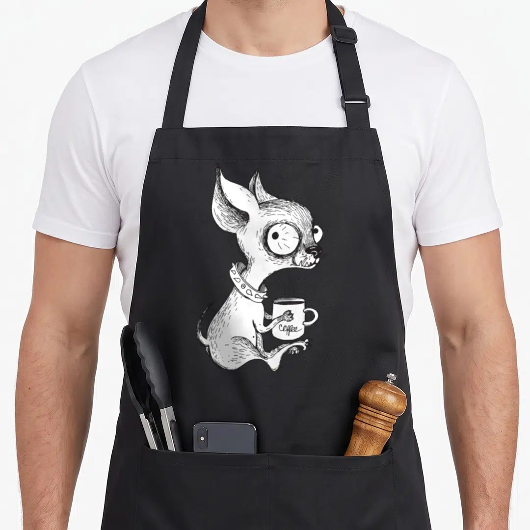 Unique coffee apron - Black and white line art of a dog with a spiked collar holding a steaming mug labeled coffee — shown on a black cotton canvas apron against a white background
