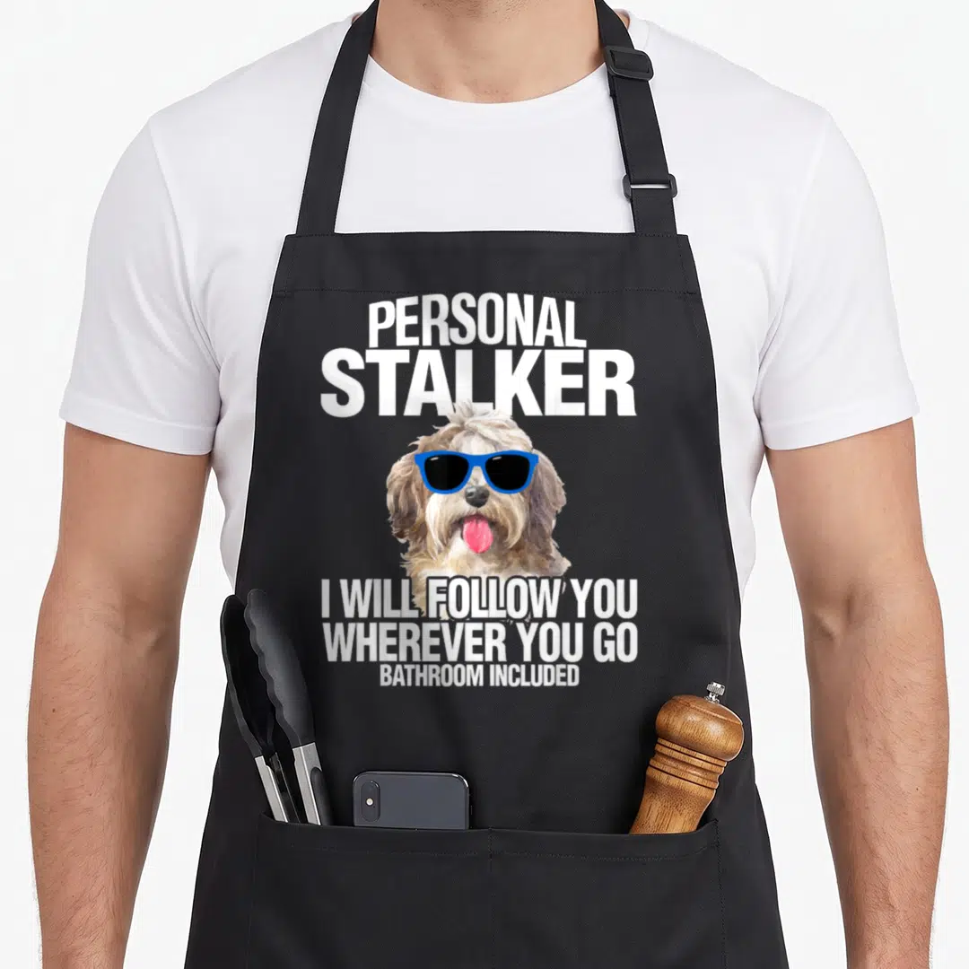 Havanese personal apron - Dog in blue sunglasses with text PERSONAL STALKER I WILL FOLLOW YOU WHEREVER YOU GO BATHROOM — shown on a black cotton canvas apron against a white background