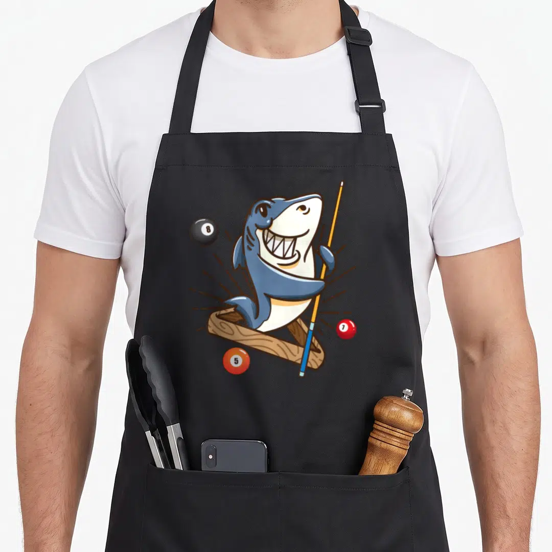 Billiard hustler apron - Cartoon shark holding cue in wooden rack with three numbered billiard balls — shown on a black cotton canvas apron against a white background