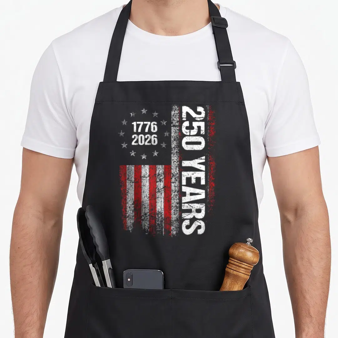 250th independence day apron - Distressed red and white USA flag with 1776 2026 and 250 YEARS text — shown on a black cotton canvas apron against a white background
