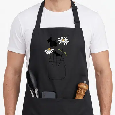 Scottie buns apron - Mason jar with two daisies and two black Scottish Terrier silhouettes in line art — shown on a black cotton canvas apron against a white background