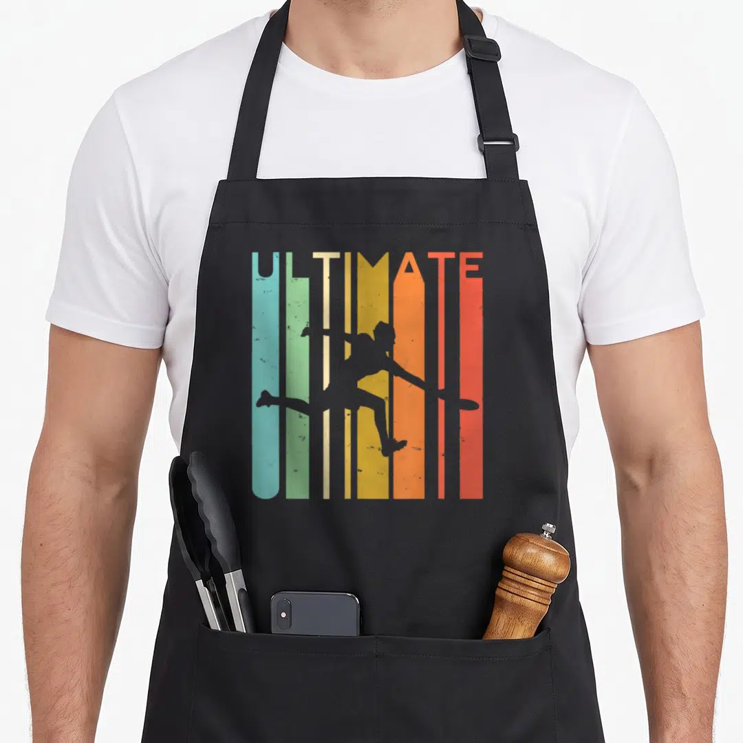 Player ultimate apron - Grey frisbee player silhouette over six vertical stripes of blue, green, yellow, orange — shown on a black cotton canvas apron against a white background