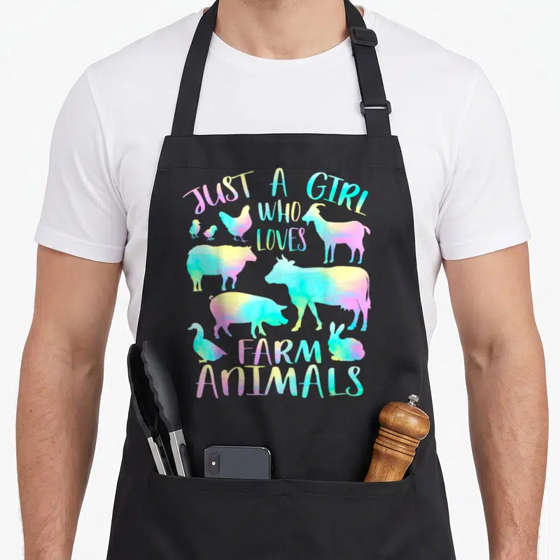 Animal cow farm aprons - Rainbow watercolor silhouettes of cows, pigs, goats, and text reading Just a Girl Who Loves — shown on a black cotton canvas apron against a white background