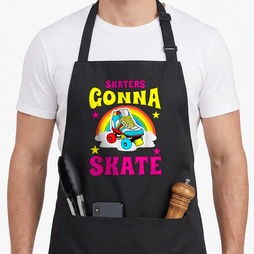 Skater roller apron - Retro roller skate on rainbow with stars and text SKATERS GONNA SKATE — shown on a black cotton canvas apron against a white background