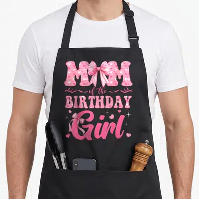 Coquette family bow apron - Pink and white typography reading MOM of the BIRTHDAY Girl with heart patterns and ribbon — shown on a black cotton canvas apron against a white background