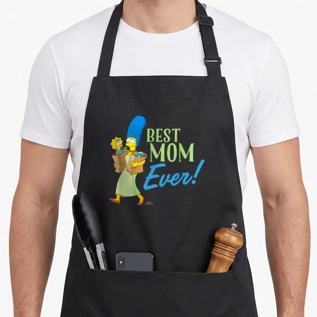 Marge simpson apron - Marge Simpson carrying Maggie in a bag next to BEST MOM Ever text in green and blue — shown on a black cotton canvas apron against a white background