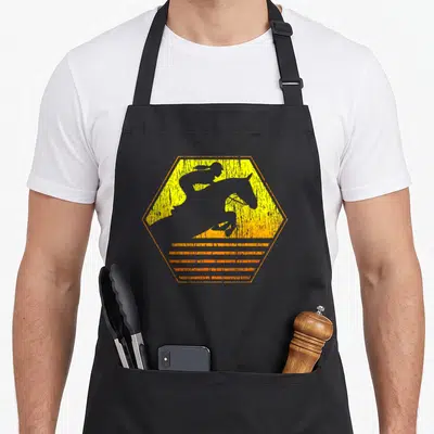 Jumping equestrian horse apron - Grey jumping horse silhouette inside distressed yellow orange hexagon with blurred — shown on a black cotton canvas apron against a white background
