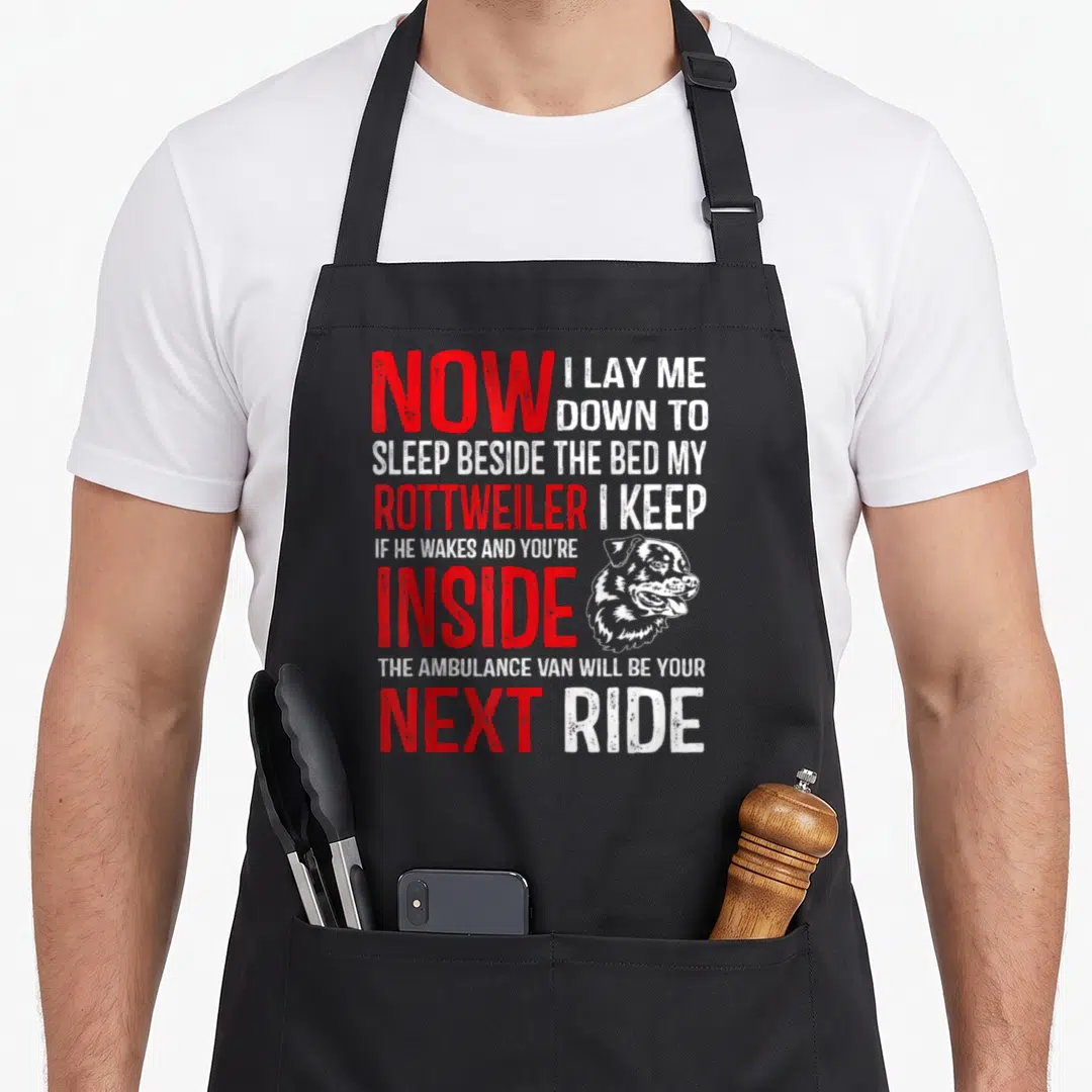 Cute rottweiler dog apron - Stacked red and white text with Rottweiler head illustration and sarcasm quote — shown on a black cotton canvas apron against a white background